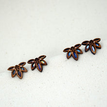 Load image into Gallery viewer, The 2 colorful pattern options of the Rise with the Sun stud earrings, small half sun shaped earrings made of laser cut wood cut in a lace pattern to let the bright yellows, blues, and pinks of the hand-painted titanium show through.