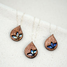Load image into Gallery viewer, the three different hand painted patterns of The Freedom to Flourish flower necklace, upside down teardrop shaped wooden and titanium necklace with a small flower cutout