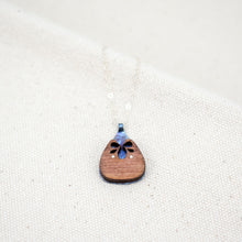 Load image into Gallery viewer, The Root of Things necklace, blue speckled titanium shining through a wooden carved rounded triangle
