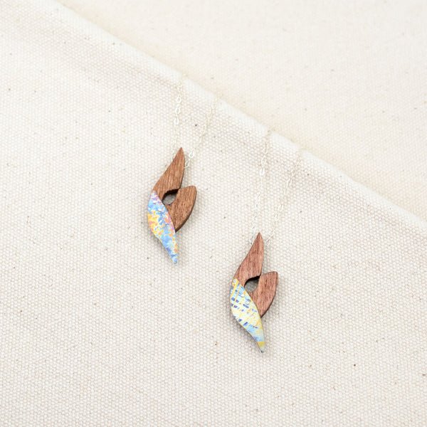 the two color variations of The Wind in Her Sails necklace, speckled pink, yellow, and blue and plaid yellow and blue