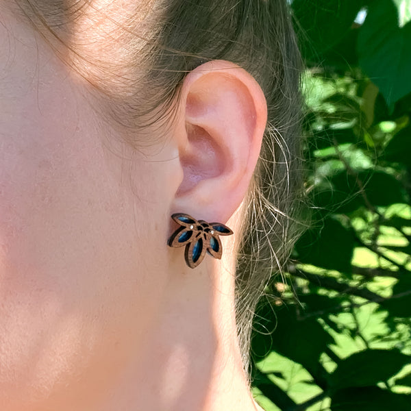 Woman modeling the Rise with the Sun stud earrings, small wooden and titanium semicircle half sun earrings hand-painted in blues and yellows.