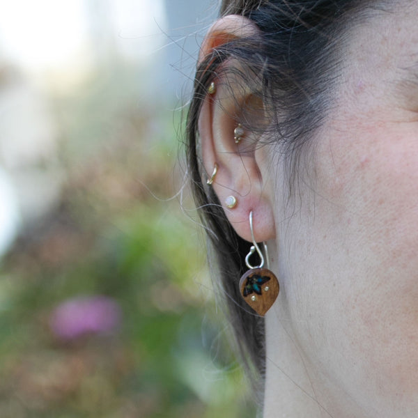 detail of woman's ear wearing The Freedom to Flourish, dainty colorful flower earrings 