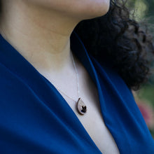Load image into Gallery viewer, close-up of woman's neckline wearing The Freedom to Flourish flower bud necklace, a dainty hand painted titanium and wood tear drop shaped necklace
