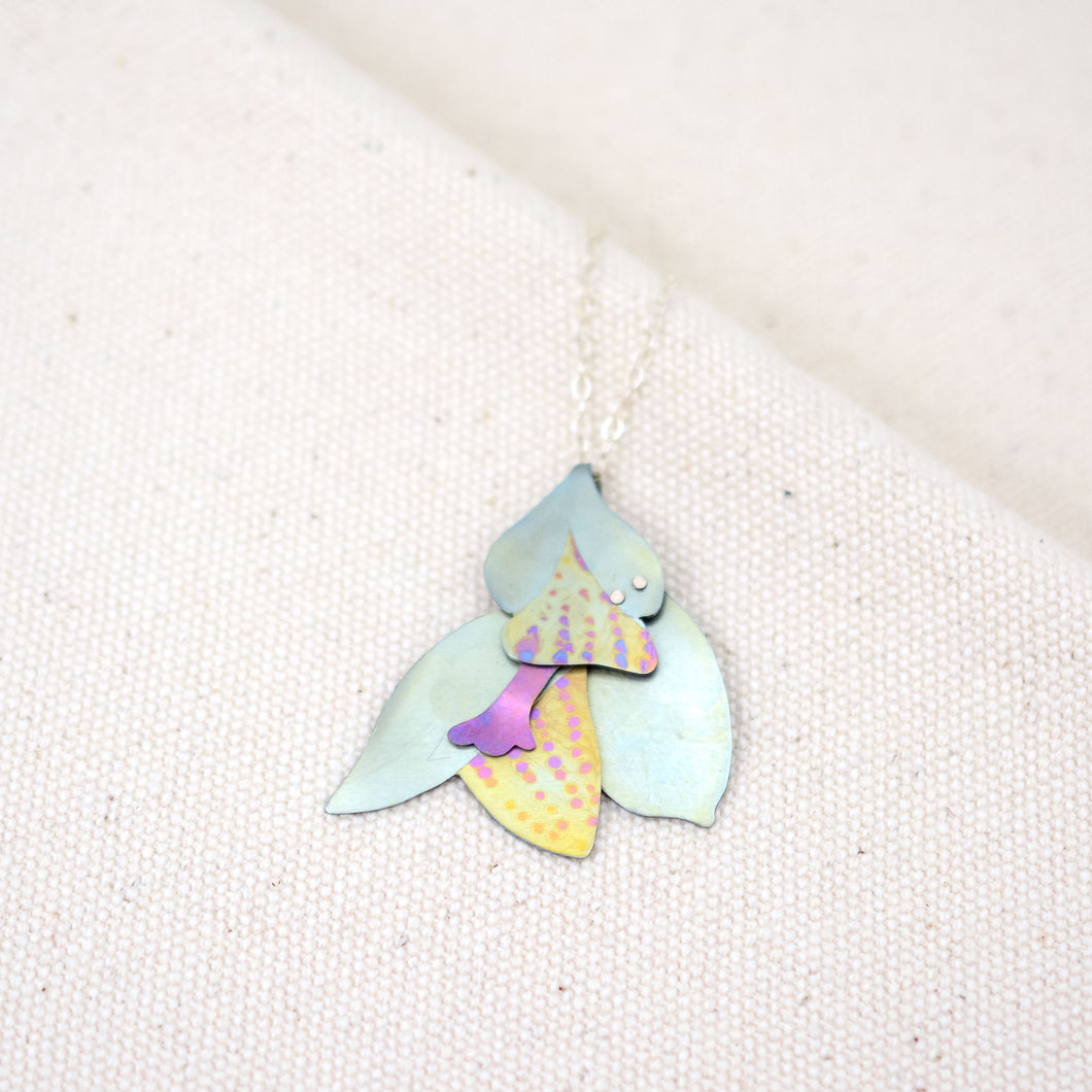 The Nectar on Her Neck necklace, flower pendant hand-painted titanium in silver-blue, yellow, and pink